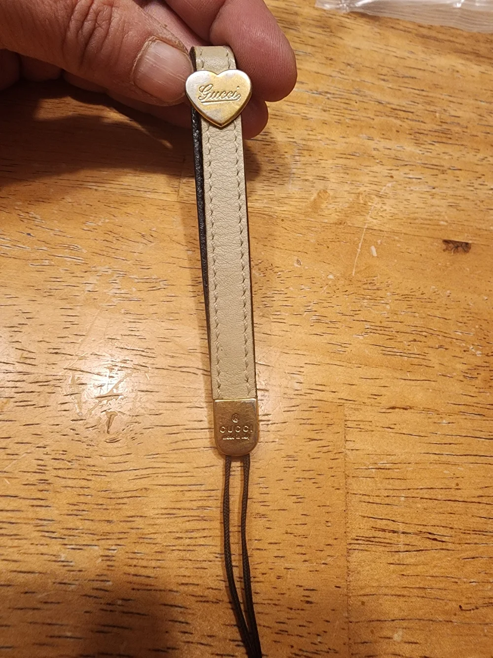 Gucci Micro Guccissima heart phone strap made of khaki leather.